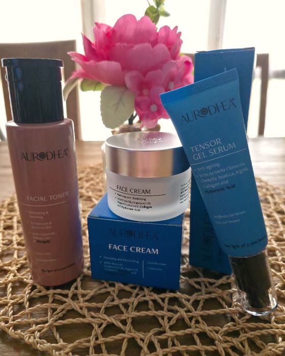 Lotion tonique, crème visage et sérum sur un set de table tressé